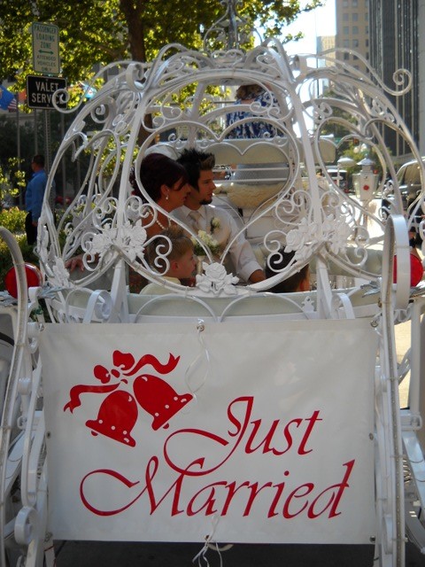 A couple is sitting in the back of a carriage.