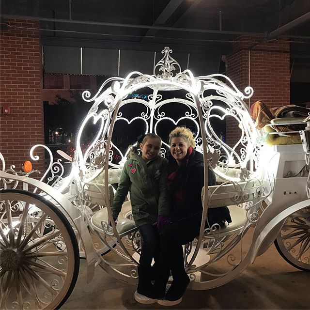 Two people standing in front of a carriage.