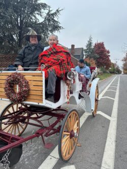 People in a horse-drawn carriage, smiling.