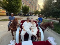 Couple in carriage with two horseback riders.